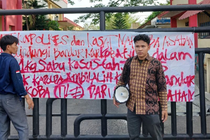 Nampak aktivis GMPSU membentangkan kain putih pada gerbang pintu Polres Asahan bertuliskan desakan untuk pengusutan kasus jaringan Narkotika di Sumatera Utara. ©okedaily.com/M. Idris Sarumpaet