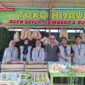 Mahasiswa KKN 02 mendampingi pelaku UMKM Desa Pajaran dalam pembuatan QRIS dan pemasangan banner sebagai upaya mendukung digitalisasi UMKM. ©okedaily.com/istimewa 