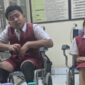 Momen penyerahan bantuan kursi roda dan meja belajar dari PT HRP Logistics kepada siswa berkebutuhan khusus di SD 2 Kesiman, Denpasar. Bantuan ini diharapkan dapat mendukung proses belajar mengajar dan meningkatkan kenyamanan siswa. ®okedaily.com